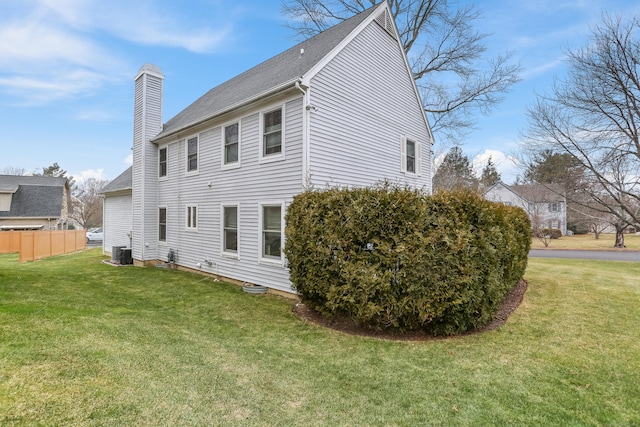 back of property with a lawn and cooling unit