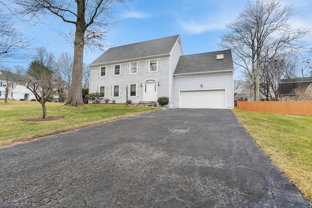 colonial inspired home with a front yard and a garage