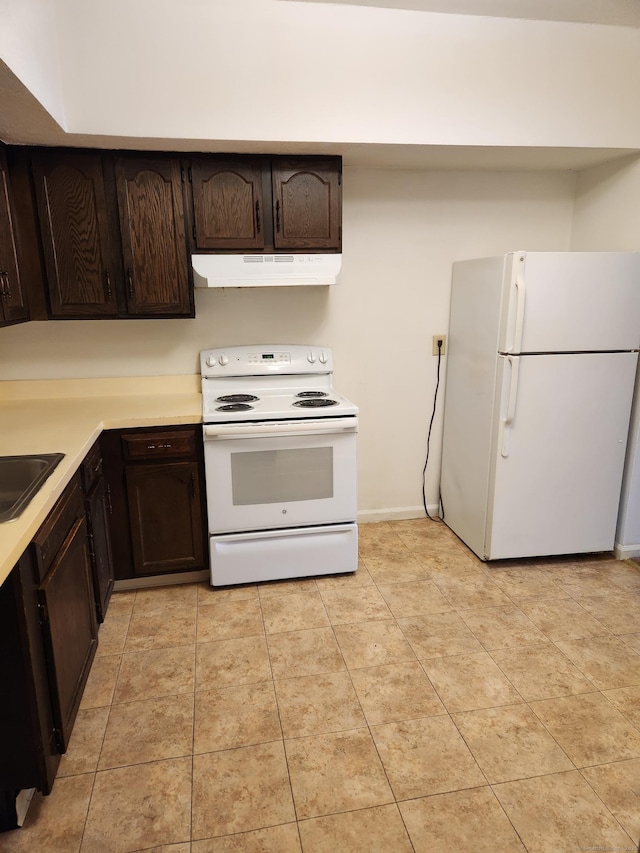 kitchen with sink, dark brown cabinets, white appliances, and light tile patterned floors