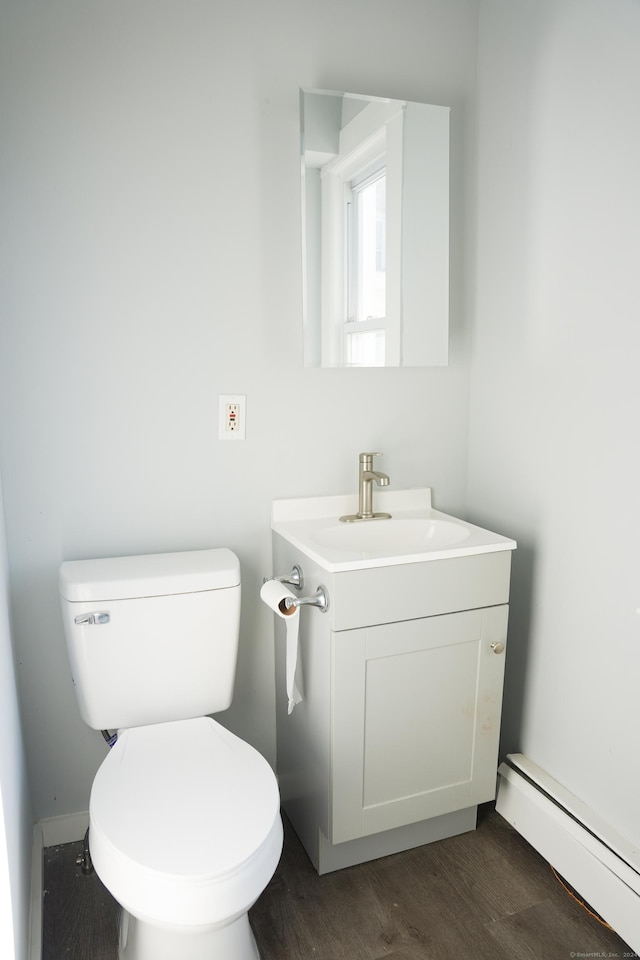 bathroom with vanity, toilet, wood-type flooring, and a baseboard radiator