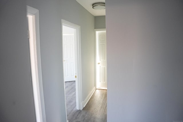 corridor with hardwood / wood-style flooring