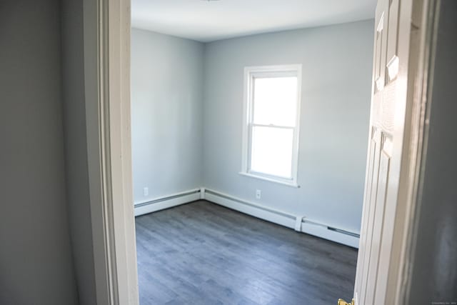 unfurnished room with a baseboard radiator and dark hardwood / wood-style floors