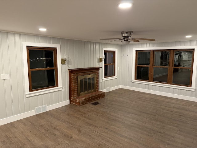 unfurnished living room with ceiling fan, dark hardwood / wood-style floors, and a fireplace