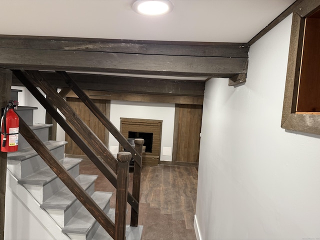 stairway featuring hardwood / wood-style flooring and a brick fireplace