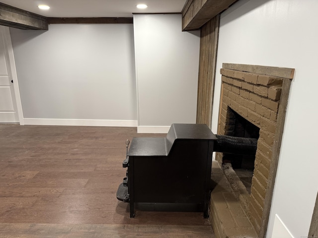 basement with hardwood / wood-style flooring and a brick fireplace