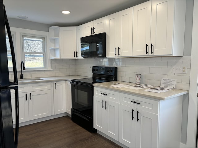 kitchen with black appliances, white cabinetry, sink, backsplash, and dark hardwood / wood-style floors