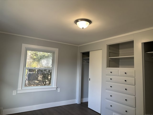 unfurnished bedroom with a closet, crown molding, and dark hardwood / wood-style floors