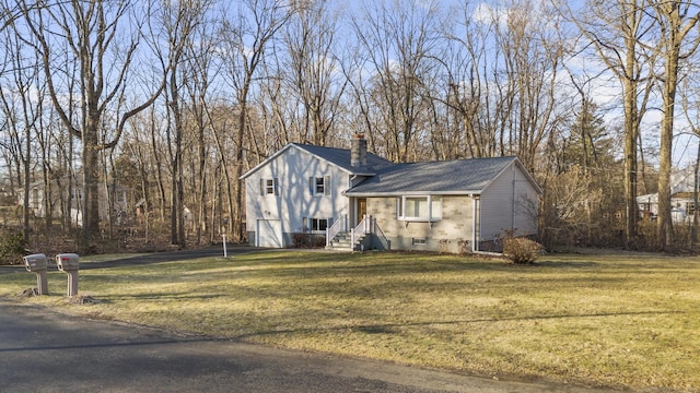 tri-level home featuring a chimney and a front lawn