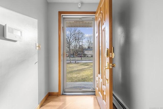 doorway to outside with baseboard heating and baseboards