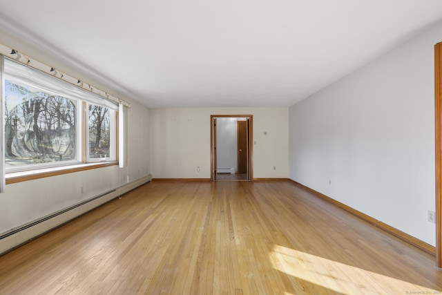 empty room with light wood-type flooring, a baseboard radiator, baseboards, and baseboard heating