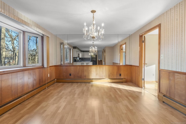 interior space with a baseboard radiator, wainscoting, and wallpapered walls