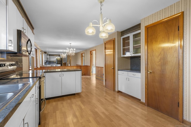 kitchen featuring wallpapered walls, stainless steel electric range oven, a peninsula, an inviting chandelier, and black microwave