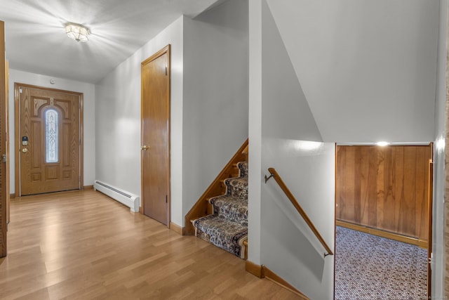 entrance foyer with a baseboard heating unit, light wood-style floors, and baseboards