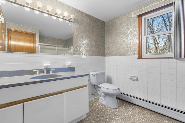 bathroom featuring wallpapered walls, toilet, a wainscoted wall, baseboard heating, and a shower stall