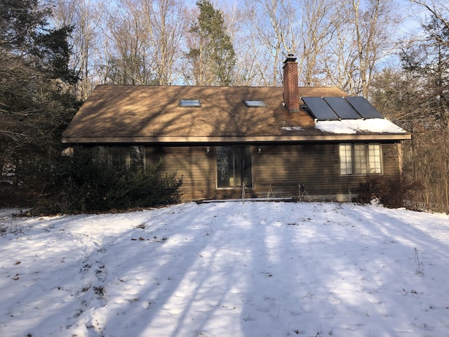 view of snow covered rear of property