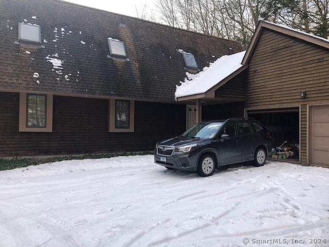 view of snowy exterior featuring a garage