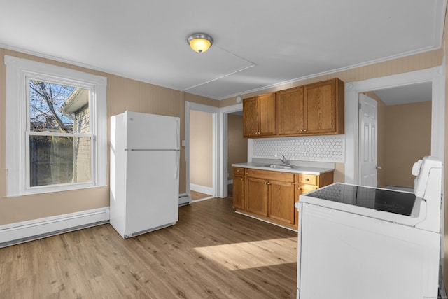 kitchen featuring sink, backsplash, light wood-type flooring, white appliances, and ornamental molding