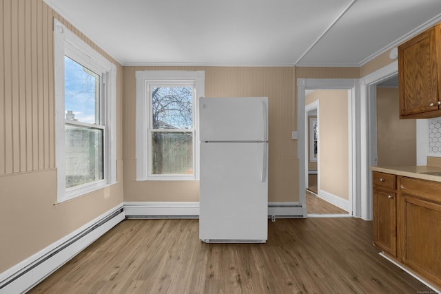 kitchen with white refrigerator, light hardwood / wood-style floors, and a baseboard heating unit