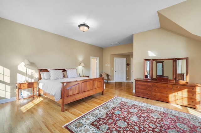 bedroom with light hardwood / wood-style flooring and high vaulted ceiling