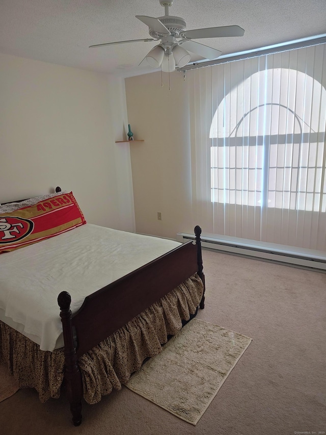 bedroom with carpet flooring, ceiling fan, a textured ceiling, and a baseboard heating unit