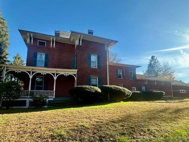 rear view of property with a lawn and a porch