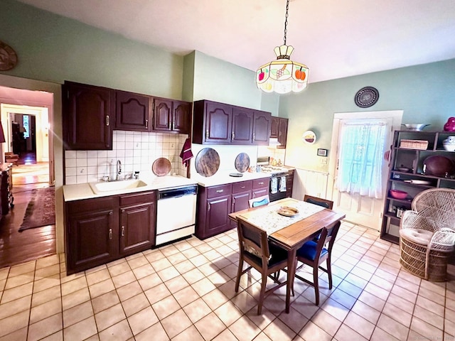 kitchen with pendant lighting, dark brown cabinets, white appliances, and sink