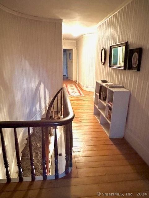 hallway with light hardwood / wood-style floors and crown molding