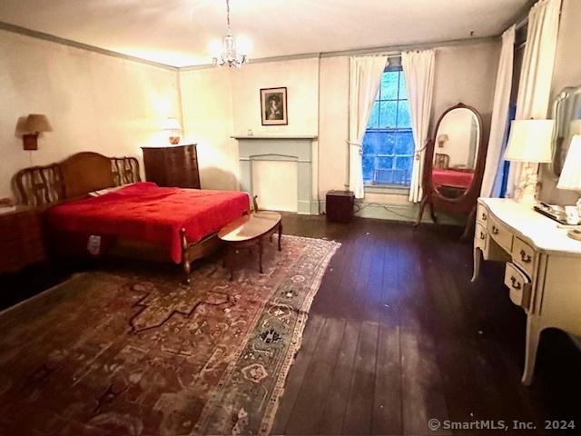 bedroom featuring dark hardwood / wood-style flooring and an inviting chandelier