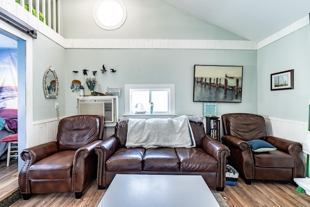 living room featuring hardwood / wood-style floors, lofted ceiling, and wood walls