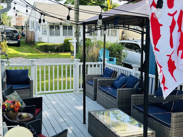 wooden terrace featuring a gazebo, a lawn, and an outdoor hangout area