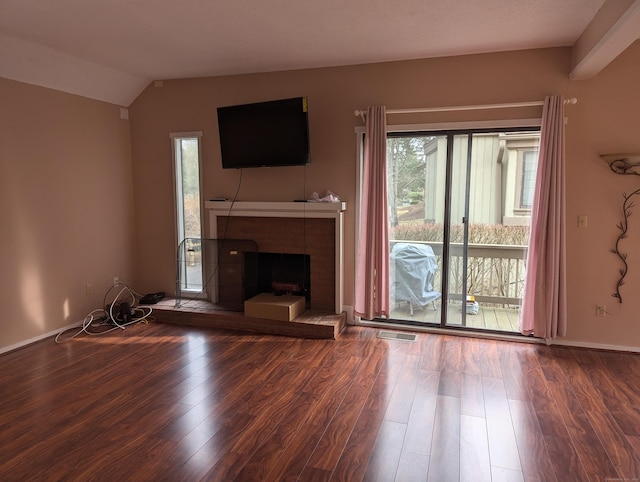 unfurnished living room with a tiled fireplace, a wealth of natural light, wood-type flooring, and lofted ceiling