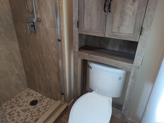 bathroom featuring toilet and tiled shower