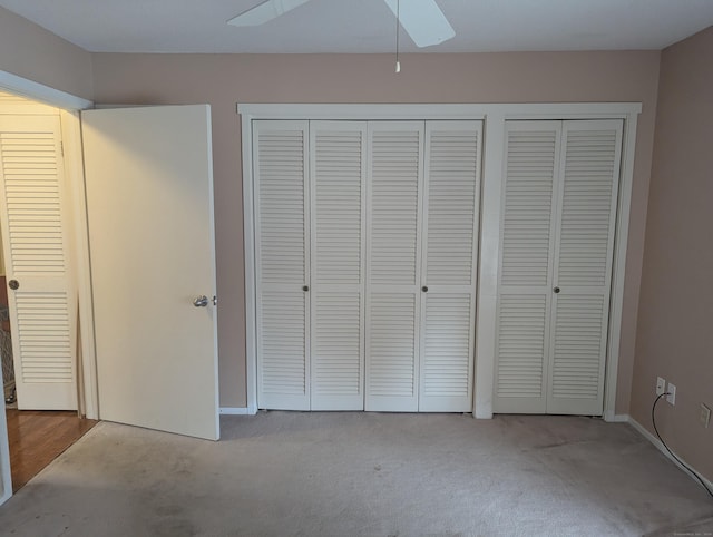 unfurnished bedroom with ceiling fan, light carpet, and two closets