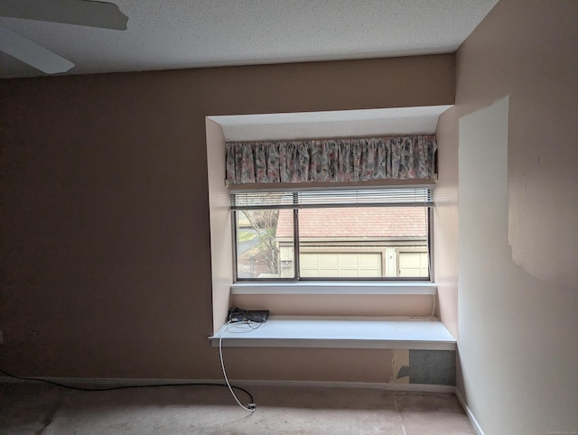 interior space with a textured ceiling and ceiling fan