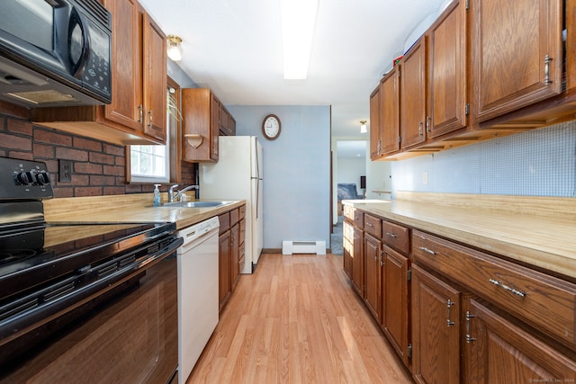 kitchen featuring backsplash, black appliances, sink, light wood-type flooring, and a baseboard radiator