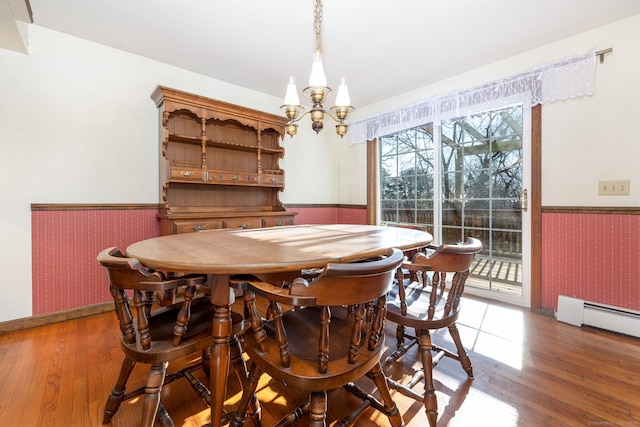 dining room with a notable chandelier, dark hardwood / wood-style flooring, and a baseboard heating unit