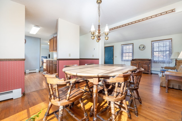 dining room with light hardwood / wood-style floors, a notable chandelier, and a baseboard heating unit