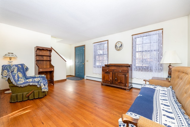 living room featuring wood-type flooring and a baseboard heating unit