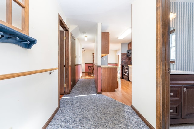 corridor featuring light colored carpet