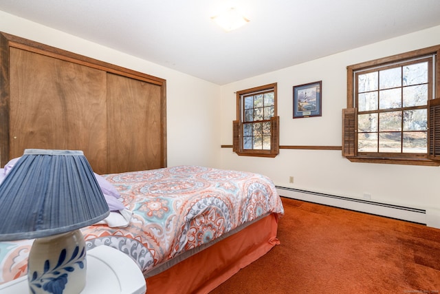 carpeted bedroom with a closet and a baseboard heating unit