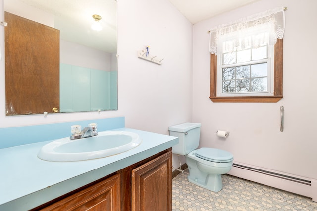 bathroom with vanity, toilet, and a baseboard heating unit