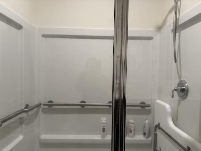 bathroom with a shower with door