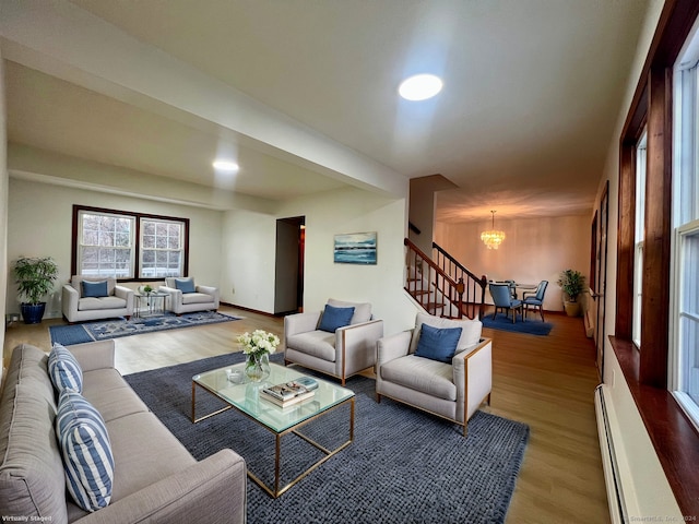 living room featuring light hardwood / wood-style floors, an inviting chandelier, and a baseboard radiator