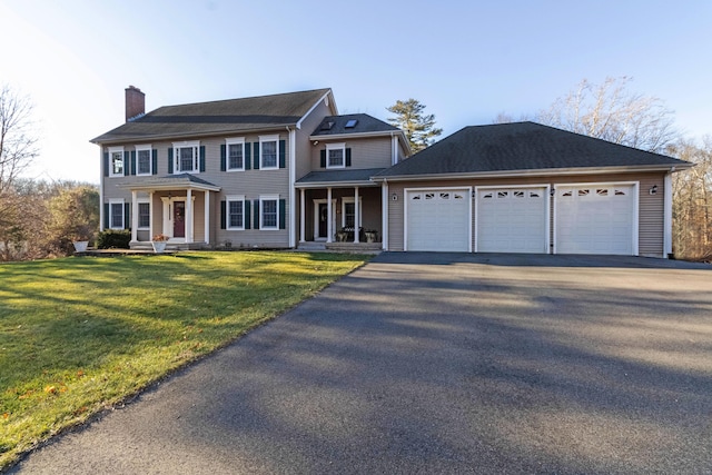 colonial-style house with a front yard, a garage, and covered porch