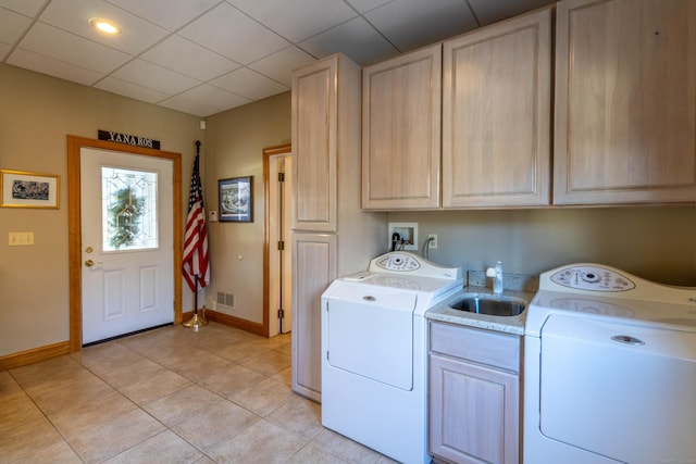 laundry room featuring washer and dryer, cabinets, and light tile patterned floors