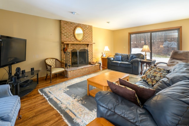 living room with hardwood / wood-style flooring and a brick fireplace