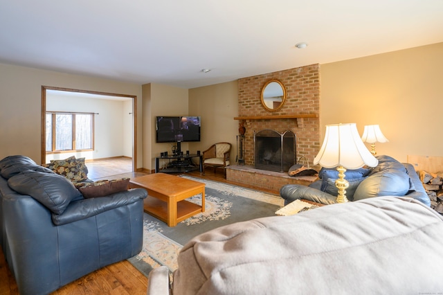 living room featuring hardwood / wood-style floors and a brick fireplace