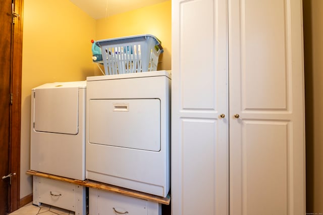 clothes washing area with light tile patterned floors and washing machine and clothes dryer