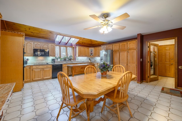 dining room with ceiling fan and lofted ceiling with skylight