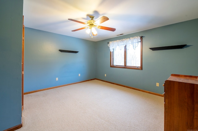 carpeted spare room with ceiling fan